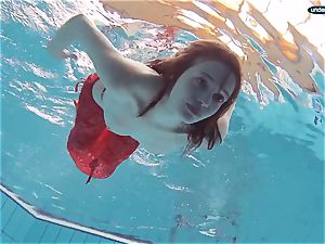 crimson dressed nubile swimming with her eyes opened